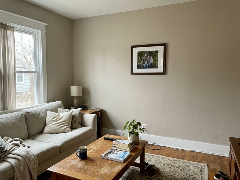 Living room walls painted Sherwin-Williams Worldly Gray SW 7043, a soft taupe-beige greige, in natural daylight