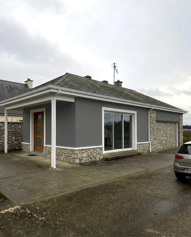 After — facade in Gauntlet Gray (SW 7019) with Pure White + Fieldstone on the trim and stone accent (Modern Ranch)