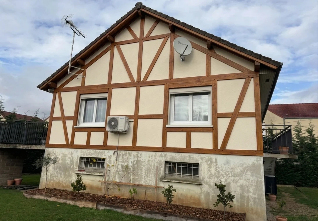 Nachher — Fassade mit Cremeweiss (RAL 9001) und Rehbraun auf den Holzbalken (Fachwerk)