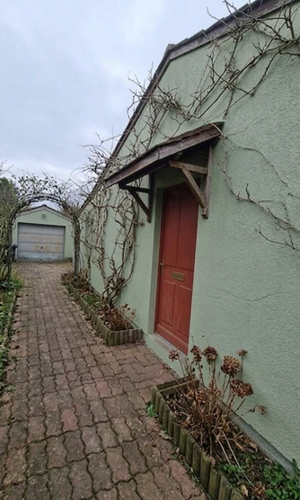 Single-story facade in Behr Hidden Gem with red door accent, AI color preview