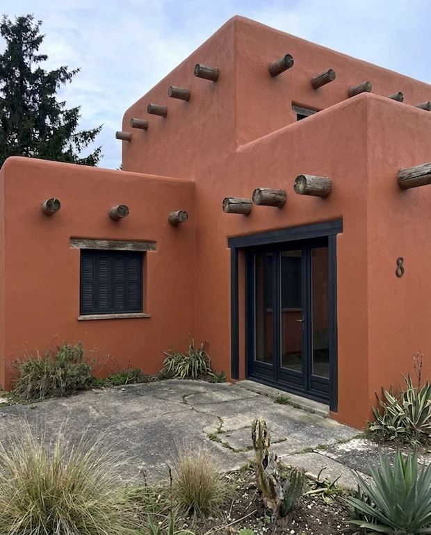 After — facade in Terracotta Stucco (Sherwin-Williams Rookwood Terra Cotta SW 2803) () with Tricorn Black (SW 6258) on the trim (Southwest / Modern Adobe)