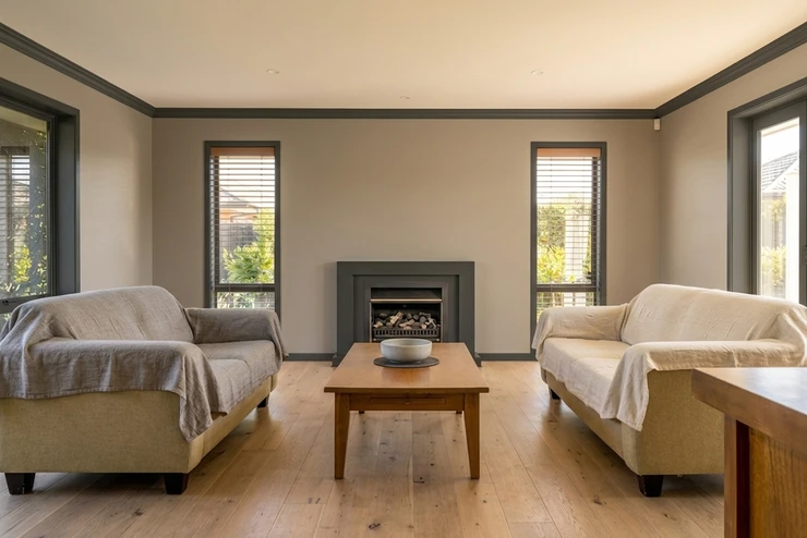 After - facade in Mushroom Greige (SW Accessible Beige SW 7036 equivalent) with Charcoal on the trim, built-in shelving and window casings (Transitional)