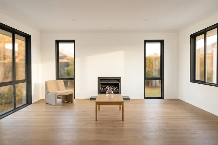 After - facade in Warm White (BM Swiss Coffee OC-45 equivalent) with Tricorn Black on the window trim, fireplace surround and interior doors (Contemporary)