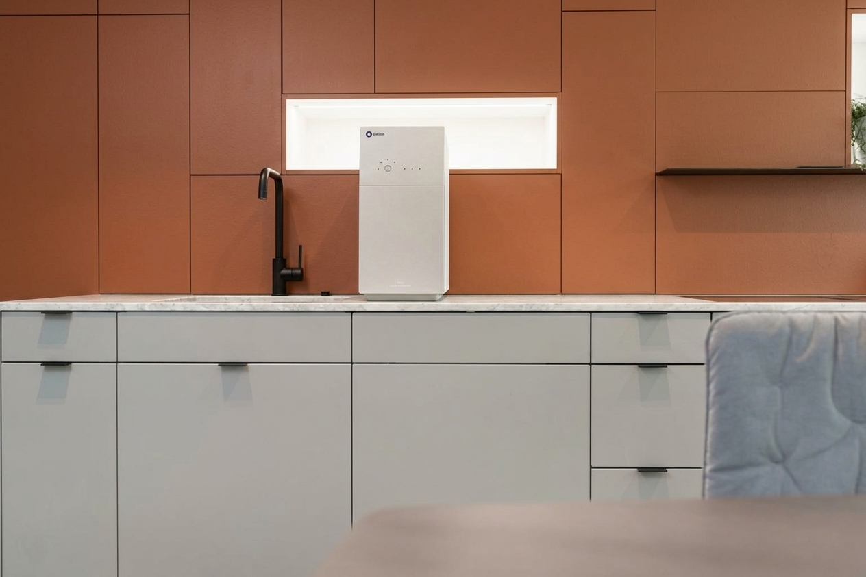 Nachher - Fassade mit Reinweiß (RAL 9010 Reinweiß) und Mattschwarz auf den Hängeschränke, Inselblock, Kochnische, Terrakotta-Akzentwand RAL 8004 (Modern Industrial)