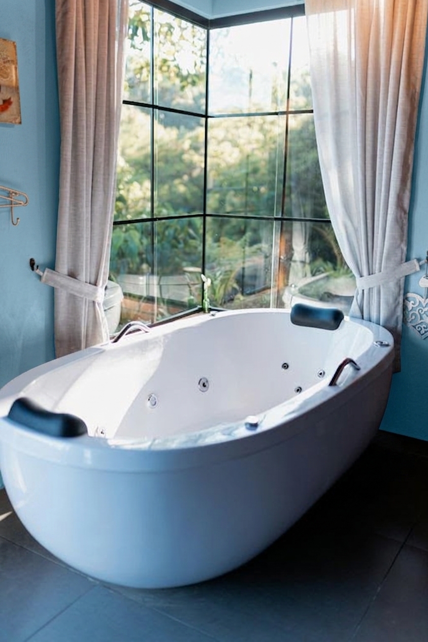 Nachher - Fassade mit Celadongrün (RAL 6019 Weißgrün) und Reinweiß auf den Decke, Sockelleisten, Sanitärobjekte, Travertin-Boden Naturton (Spa Wellness)